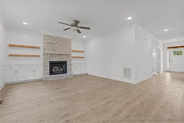 an empty room with windows and fireplace