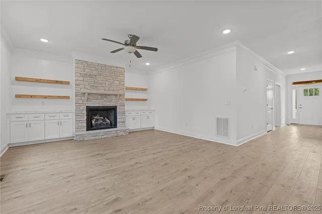 an empty room with windows and fireplace