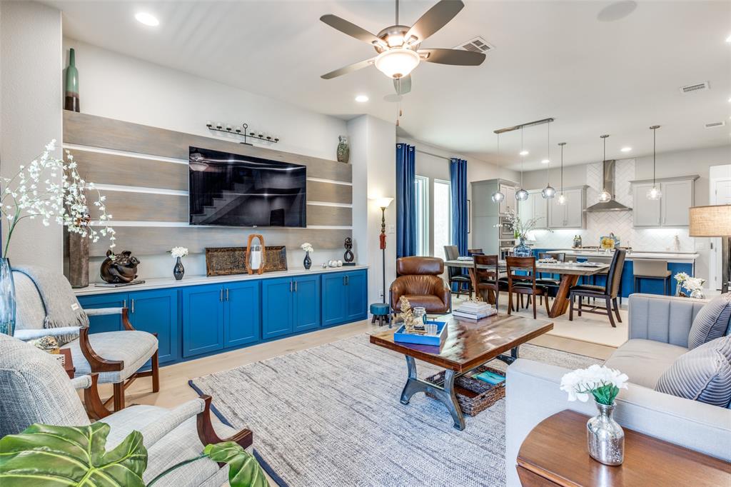a living room with furniture kitchen view and a wooden floor