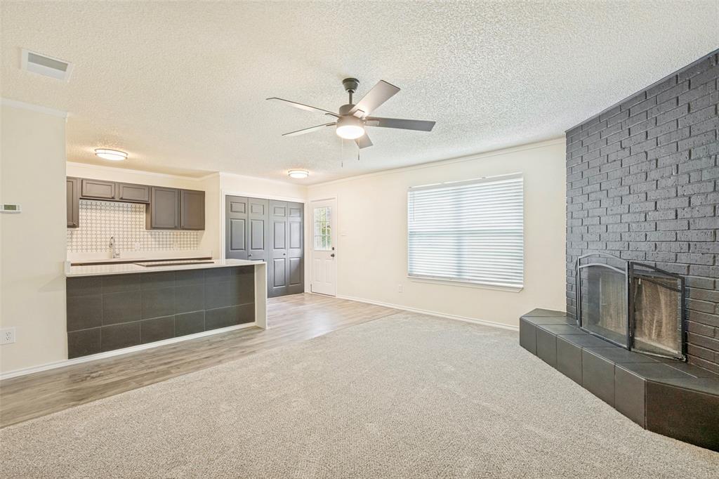 5901 Myers Road Arlington, TX 76017 - Photo 6 of 23 a spacious bedroom with a fireplace and a ceiling fan
