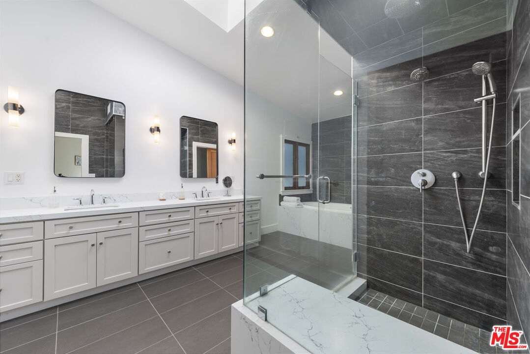 2601 Nichols Canyon Road Los Angeles, CA 90046 - Photo 12 of 28 a spacious bathroom with a shower a sink and a mirror