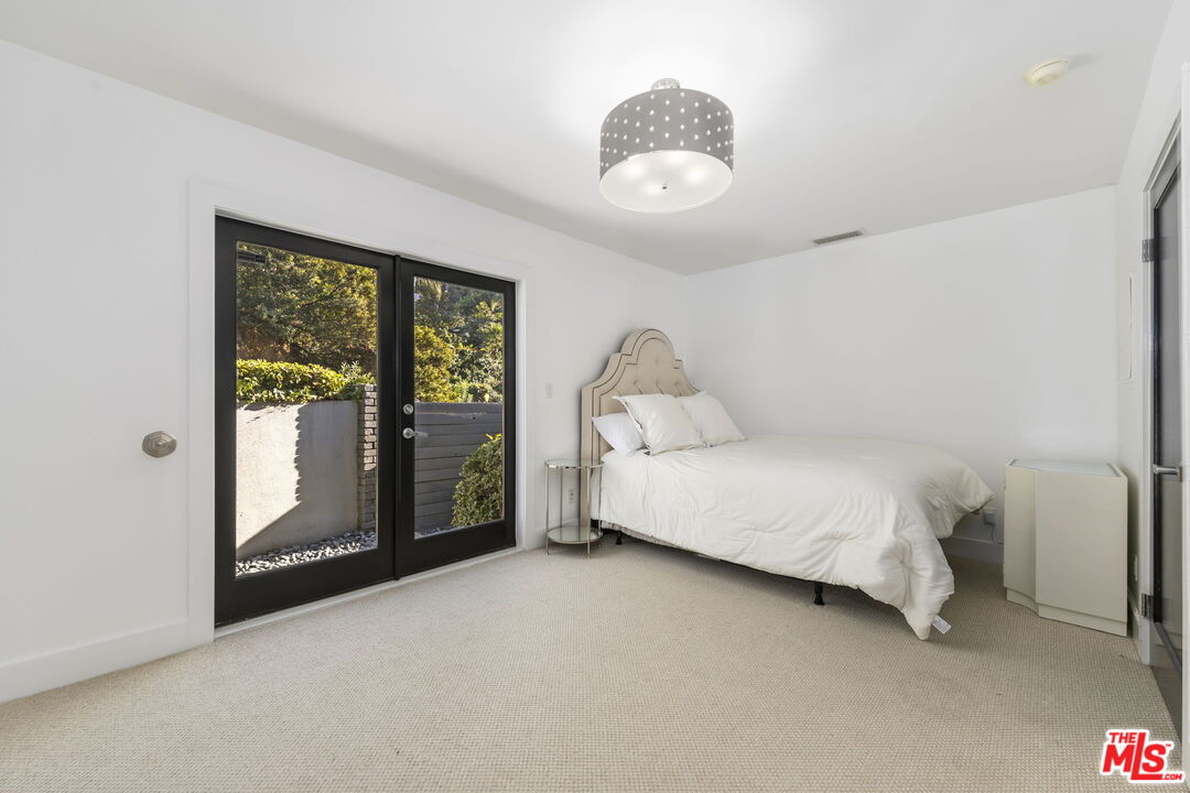 2601 Nichols Canyon Road Los Angeles, CA 90046 - Photo 13 of 28 a bedroom with a bed and sliding door