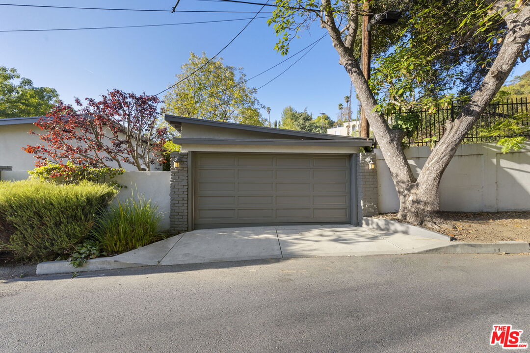 2601 Nichols Canyon Road Los Angeles, CA 90046 - Photo 23 of 28 a front view of a house with a yard and garage