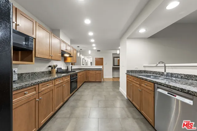 a kitchen with stainless steel appliances granite countertop a refrigerator and a sink