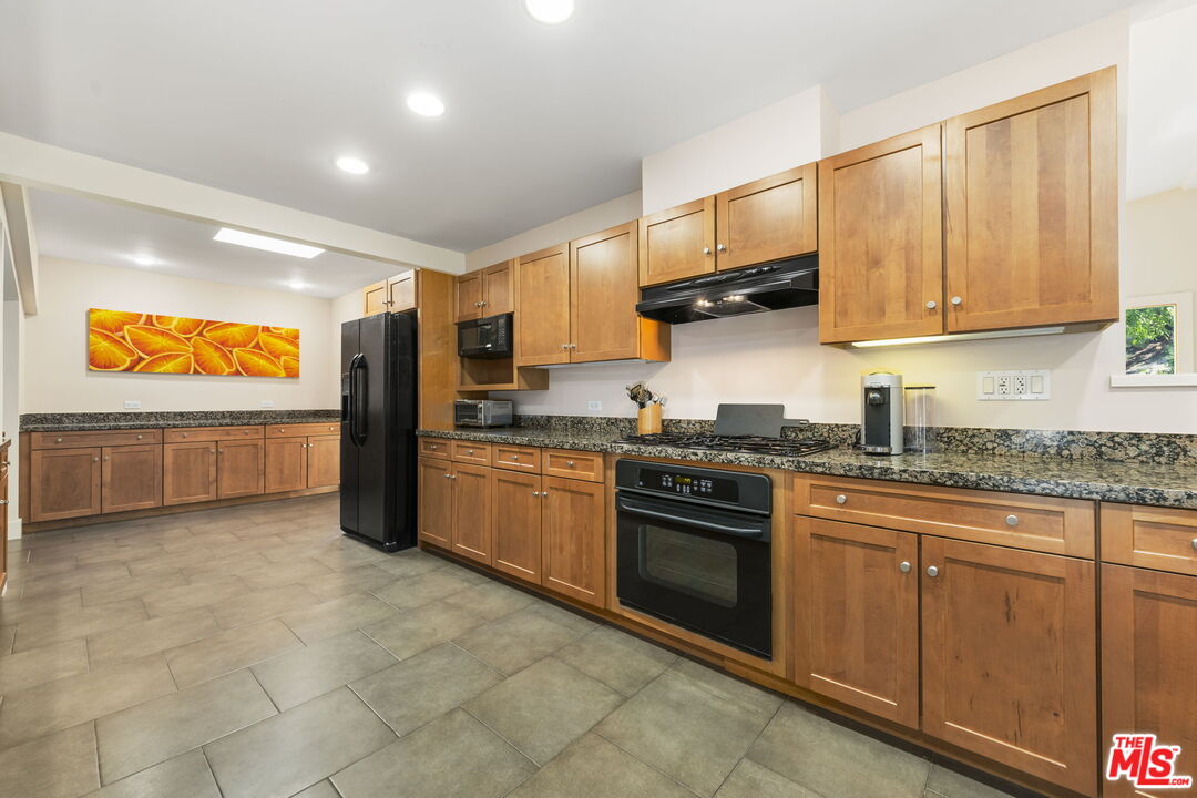 2601 Nichols Canyon Road Los Angeles, CA 90046 - Photo 6 of 28 a kitchen with stainless steel appliances granite countertop a stove sink and cabinets