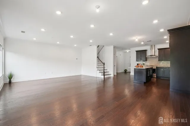 a view of empty room with wooden floor and seating