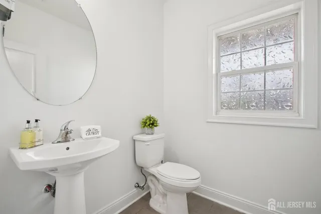 a bathroom with a sink a toilet and a mirror