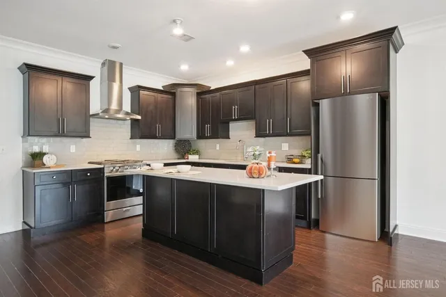 a kitchen with kitchen island granite countertop appliances cabinets and a sink