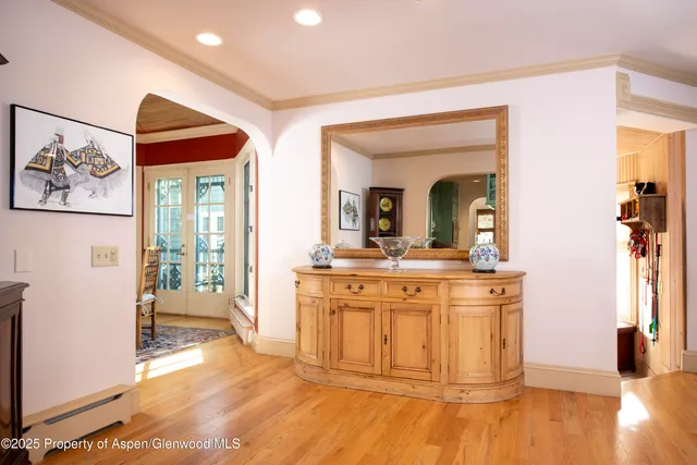 a dining room with furniture large windows and wooden floor