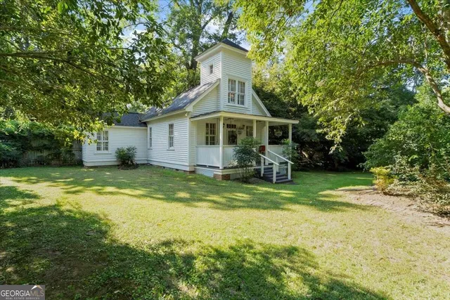 a aerial view of a house next to a yard with large trees
