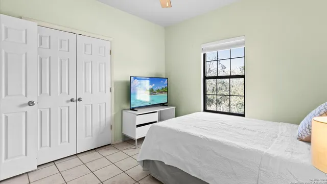 a bedroom with a bed and a flat screen tv