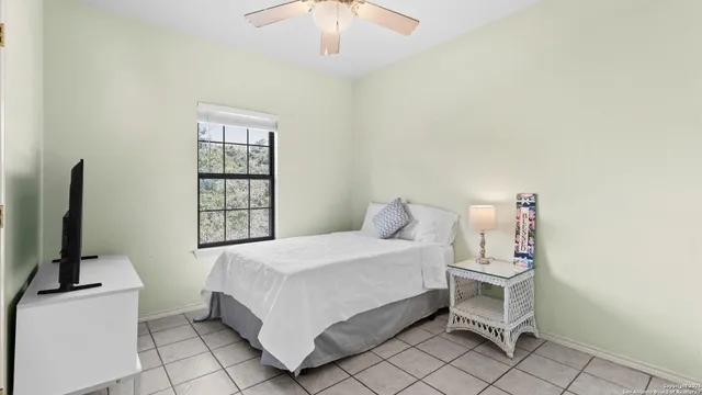 a view of yellow house with a yard and large tree