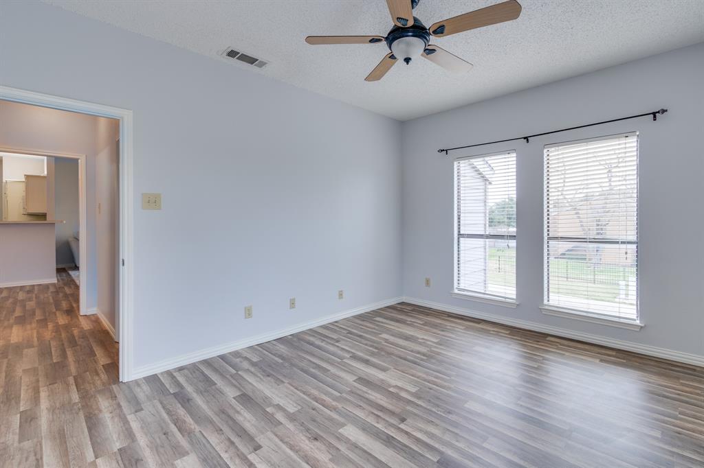 2100 Randy Snow Road, Unit 412 Arlington, TX 76011 - Photo 22 of 32 a view of a livingroom with wooden floor and a ceiling fan