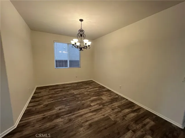 a view of a room with wooden floor chandelier and a window