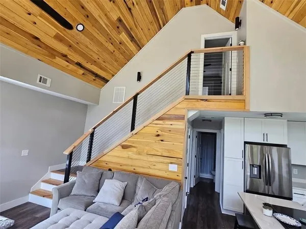 a kitchen with stainless steel appliances kitchen island granite countertop a table chairs in it and wooden floors