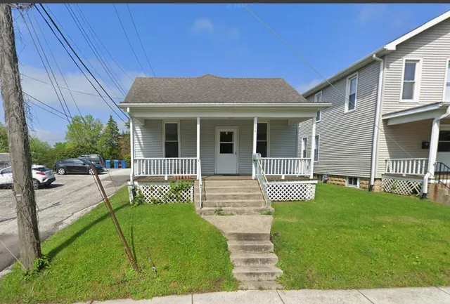 a view of a house with backyard and porch