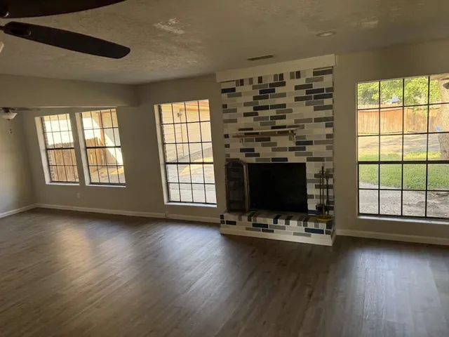 a living room with fireplace furniture and a large window