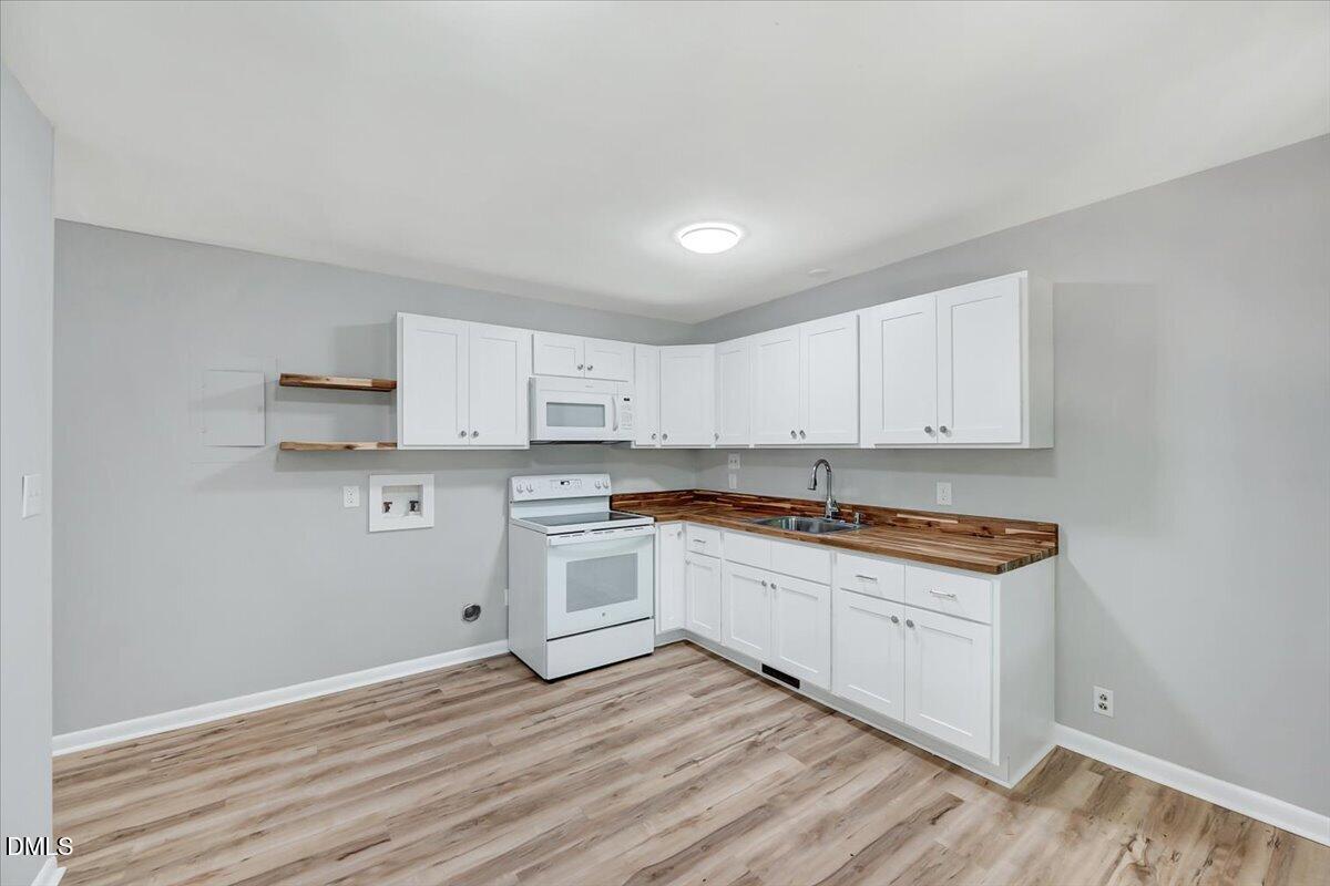 3408 Atlantic Avenue Raleigh, NC 27604 - Photo 11 of 48 a kitchen with granite countertop white cabinets and white appliances