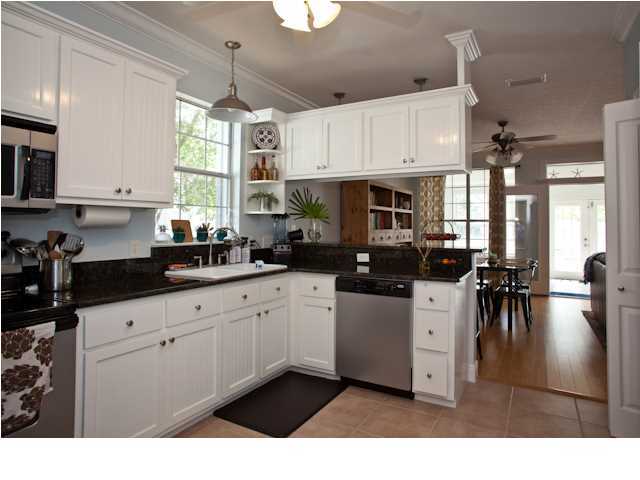 258 Seabreeze Circle Seacrest, FL 32461 - Photo 15 of 31 a kitchen with stainless steel appliances kitchen island granite countertop a sink dishwasher a stove and white cabinets with wooden floor