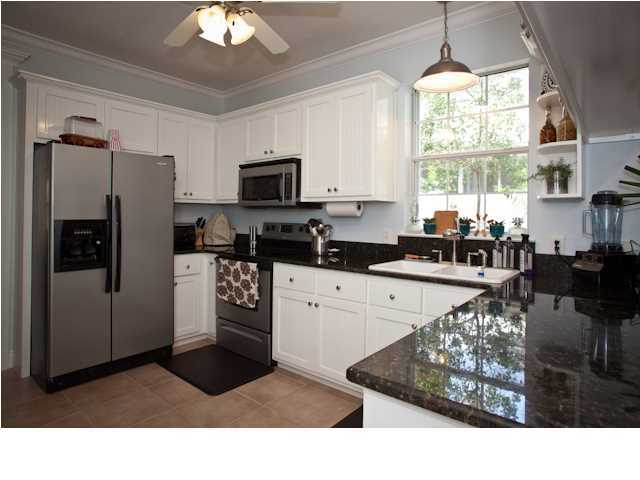 258 Seabreeze Circle Seacrest, FL 32461 - Photo 16 of 31 a kitchen with stainless steel appliances kitchen island granite countertop a refrigerator oven a sink a dining table and chairs with the large mirror