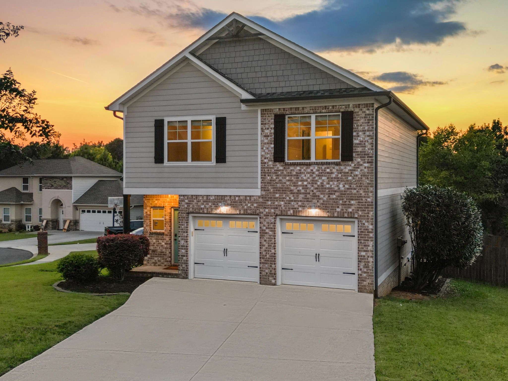 a front view of a house with a garden and parking space