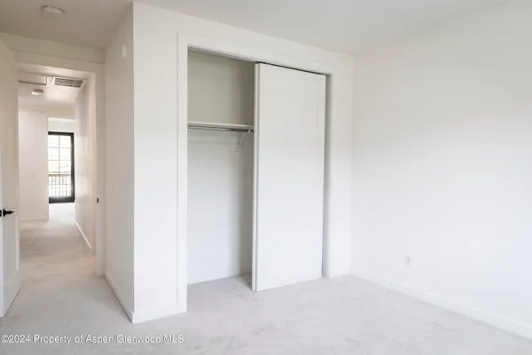 an empty room with windows and closet