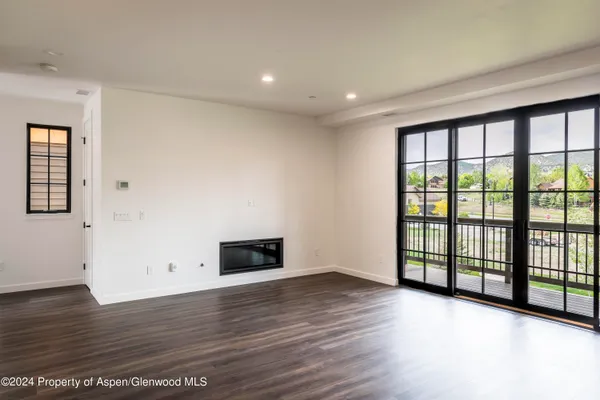 a view of empty room with wooden floor and fireplace