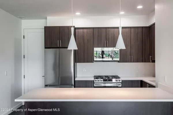 a kitchen with a refrigerator and a stove