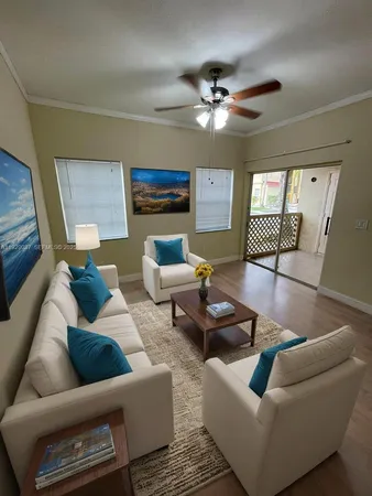 a living room with furniture and a ceiling fan