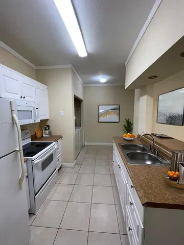 a kitchen with a sink a stove and cabinets