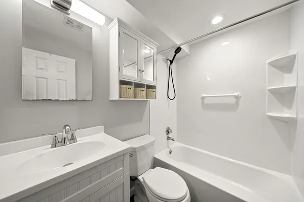 a bathroom with a sink toilet vanity and shower