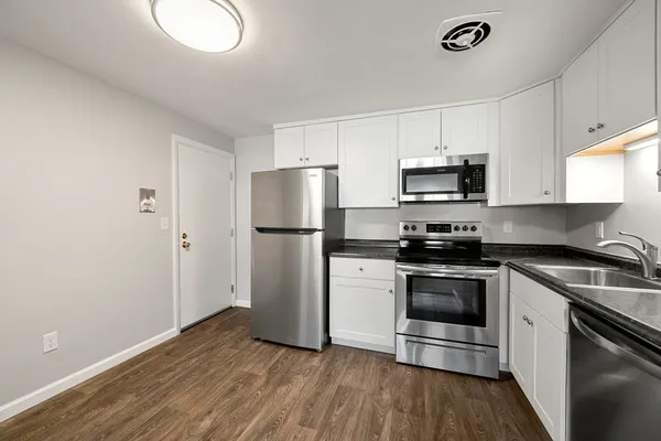 a kitchen with a sink a refrigerator and a stove top oven