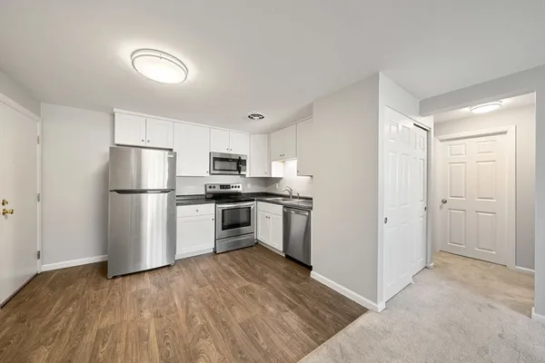 a kitchen with a refrigerator and a stove top oven
