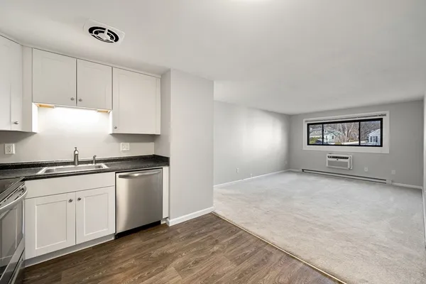 a kitchen with granite countertop a sink and cabinets