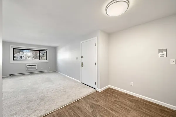 an empty room with windows and mirror
