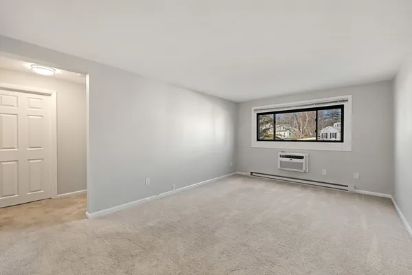 an empty room with windows and mirror