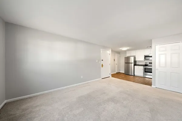 a view of a kitchen with refrigerator and chairs