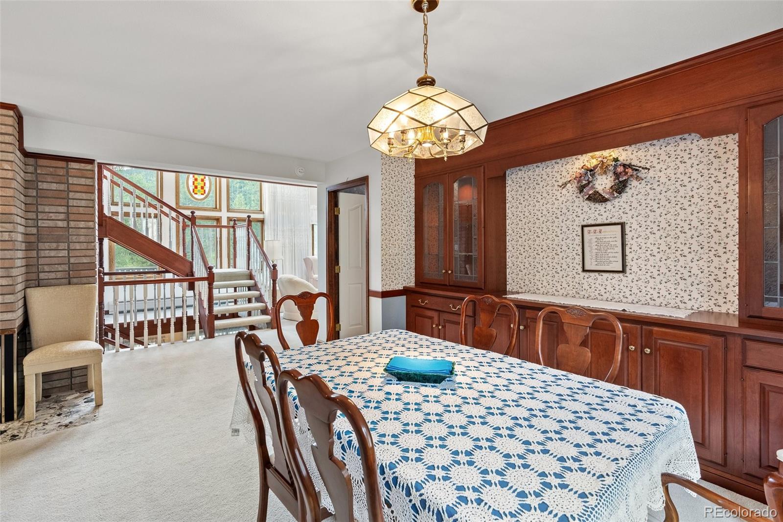 1680 Crow Valley Road Bailey, CO 80421 - Photo 12 of 50 a view of a dining room with furniture a chandelier and large window