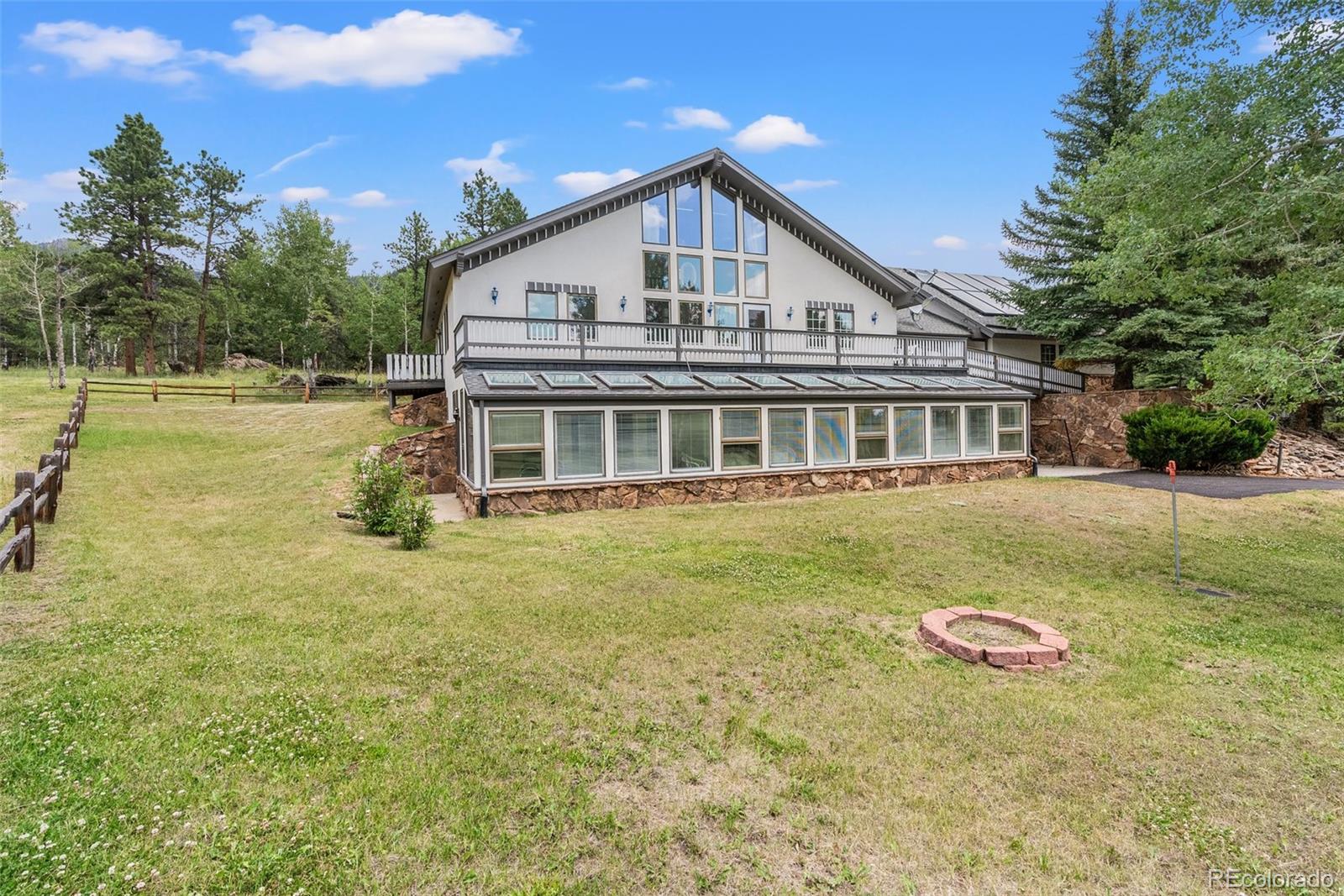 1680 Crow Valley Road Bailey, CO 80421 - Photo 2 of 50 a view of a house with a yard table and chairs