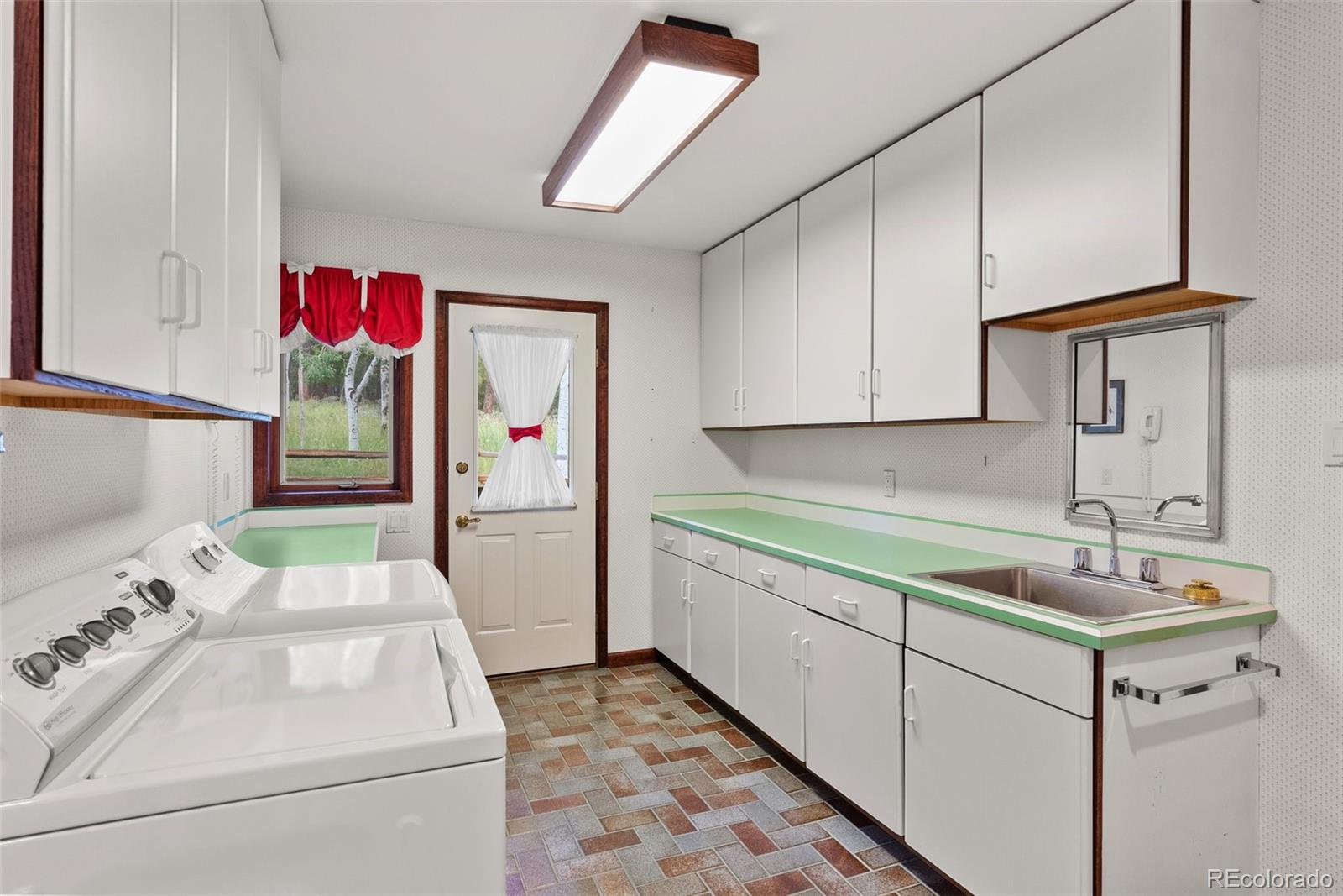 1680 Crow Valley Road Bailey, CO 80421 - Photo 34 of 50 a bathroom with a sink and mirror with bathtub