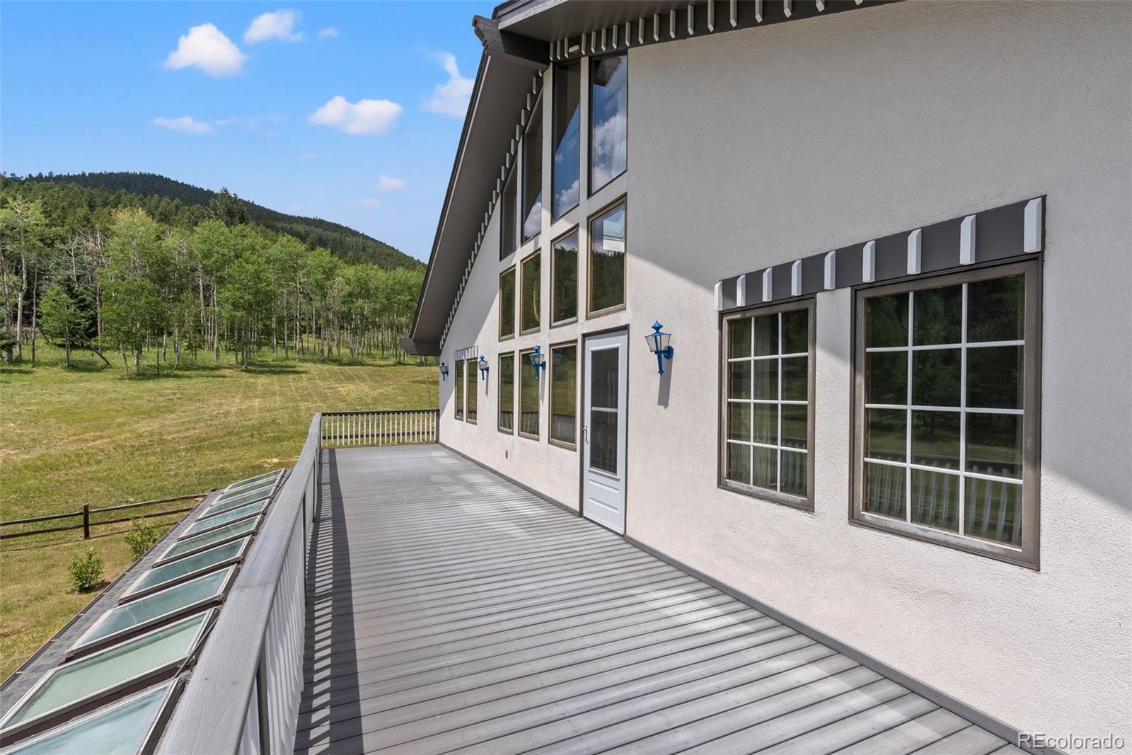 1680 Crow Valley Road Bailey, CO 80421 - Photo 6 of 50 a view of balcony with wooden floor and lake view