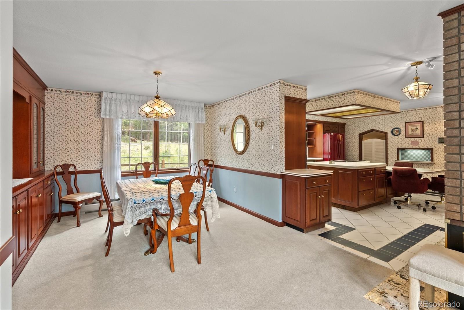 1680 Crow Valley Road Bailey, CO 80421 - Photo 10 of 50 a living room with furniture a chandelier and a dining table