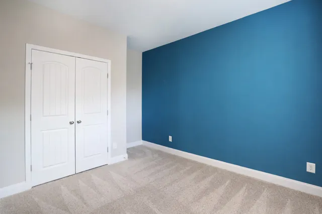 an empty room with closet and a ceiling fan