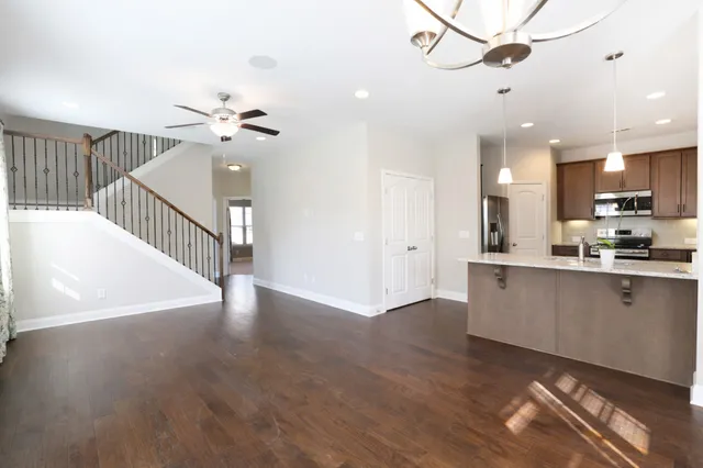 a view of a kitchen with wooden floor and a ceiling fan