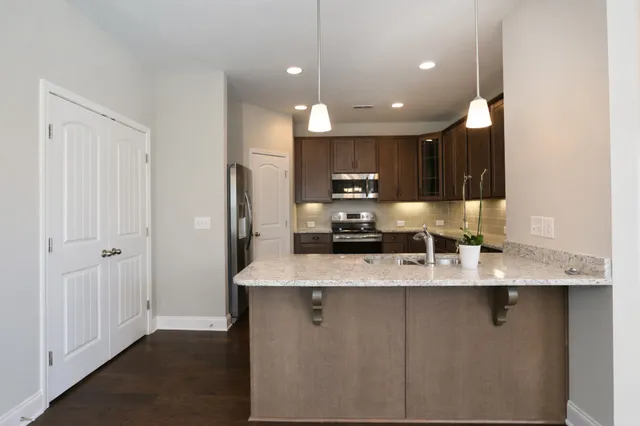 a large kitchen with kitchen island a sink stainless steel appliances and cabinets