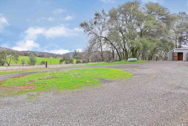 a kitchen with granite countertop a refrigerator stove top oven and cabinets with wooden floor