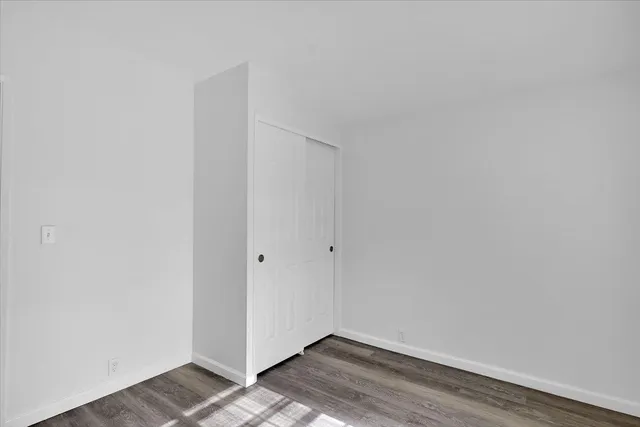 a bathroom with a granite countertop toilet sink mirror and vanity