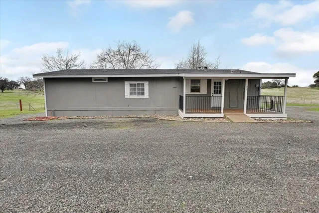 a front view of house with yard and trees around