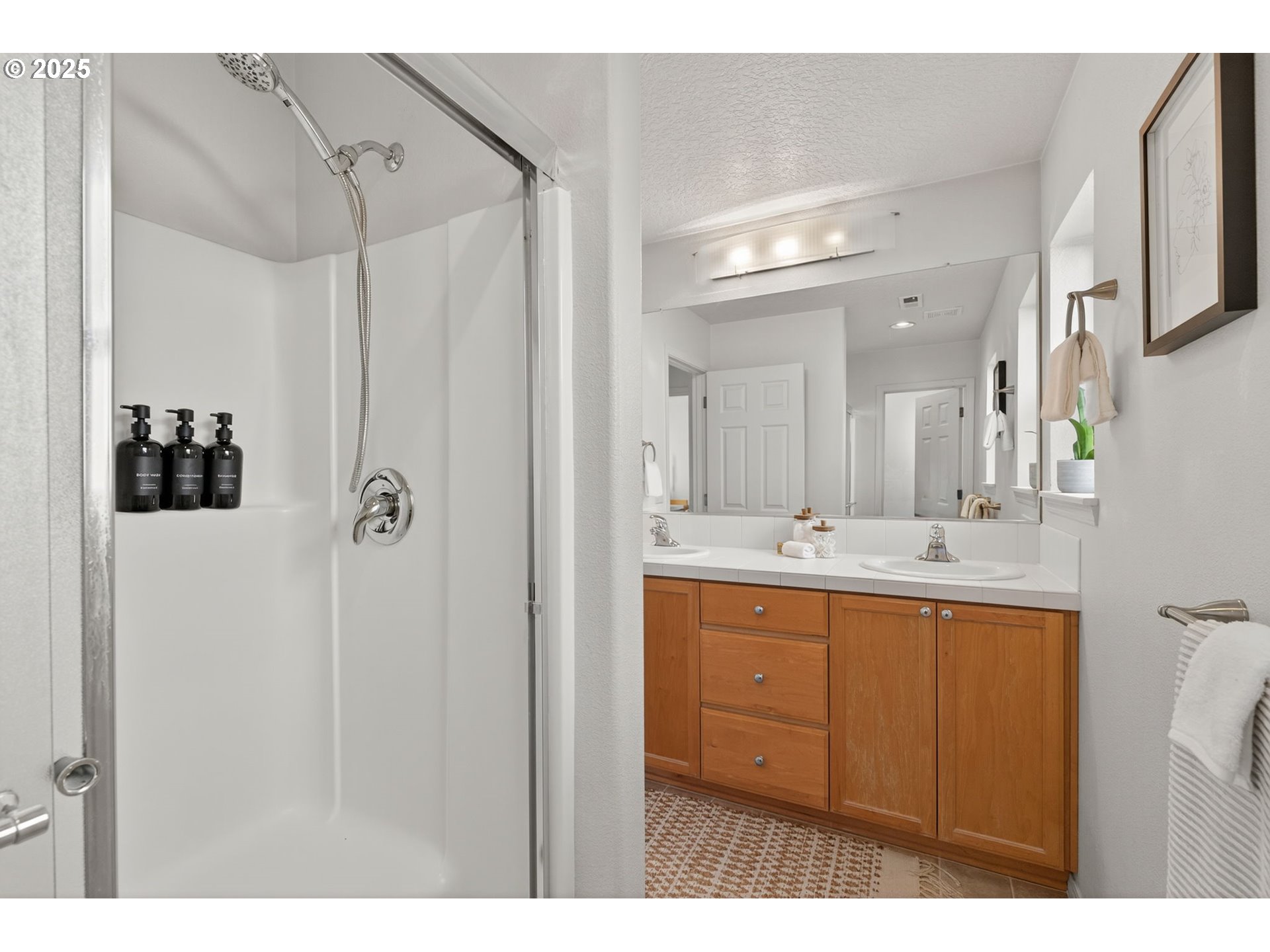 6262 Southwest 205th Avenue Beaverton, OR 97078 - Photo 24 of 36 a bathroom with a double vanity sink a mirror and shower