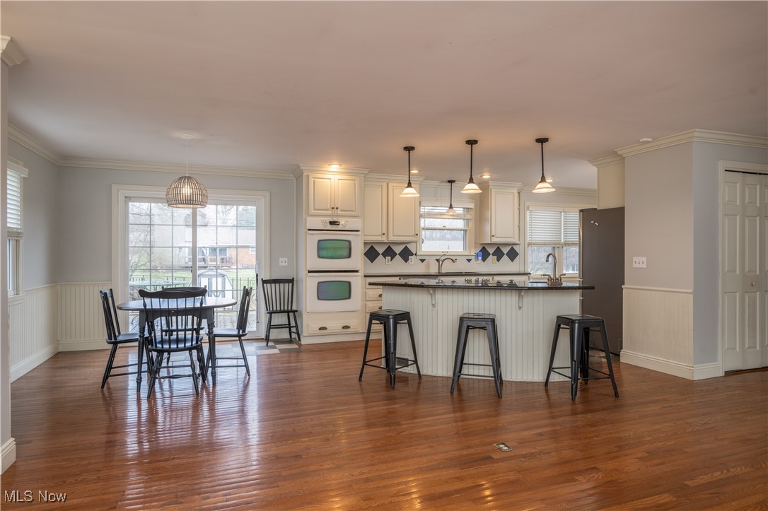 3721 20th Street Northwest Canton, OH 44708 - Photo 9 of 47 Kitchen featuring a breakfast bar area, decorative light fixtures, stainless steel refrigerator, white double oven, and white cabinets
